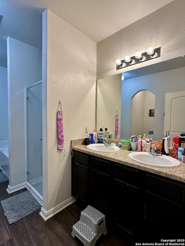 bathroom with vanity, an enclosed shower, wood-type flooring, and a textured ceiling