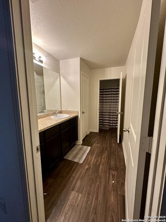 bathroom with vanity, hardwood / wood-style floors, and a textured ceiling