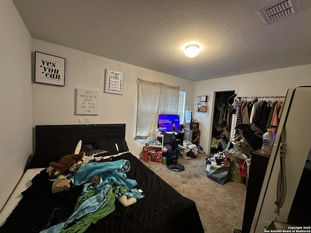 carpeted bedroom featuring a textured ceiling and a closet