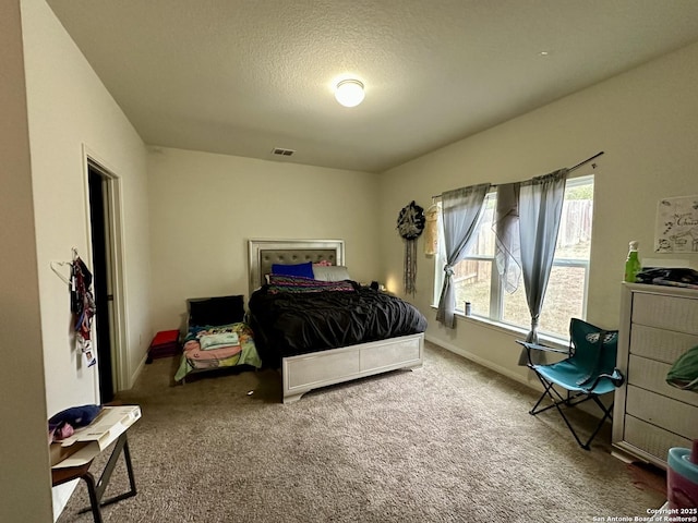 bedroom with carpet and a textured ceiling