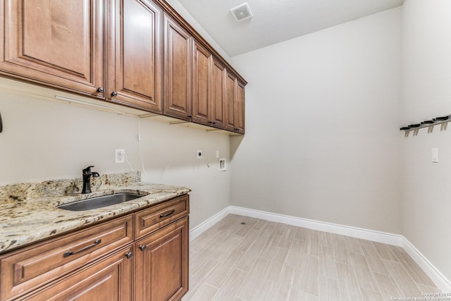 washroom with hookup for a washing machine, sink, cabinets, and hookup for an electric dryer