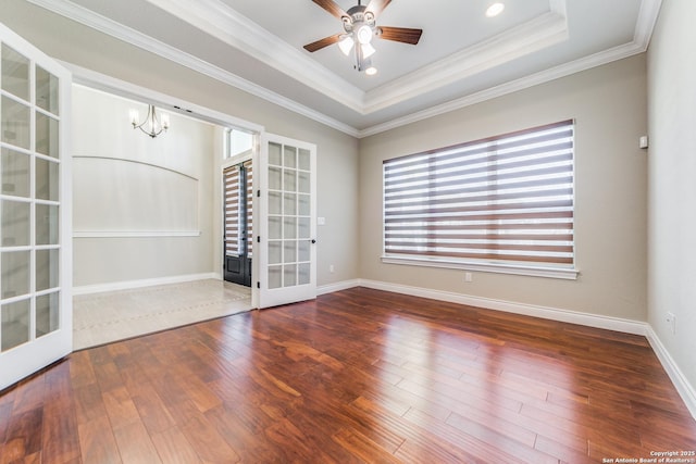 spare room with hardwood / wood-style flooring, ornamental molding, a tray ceiling, and french doors