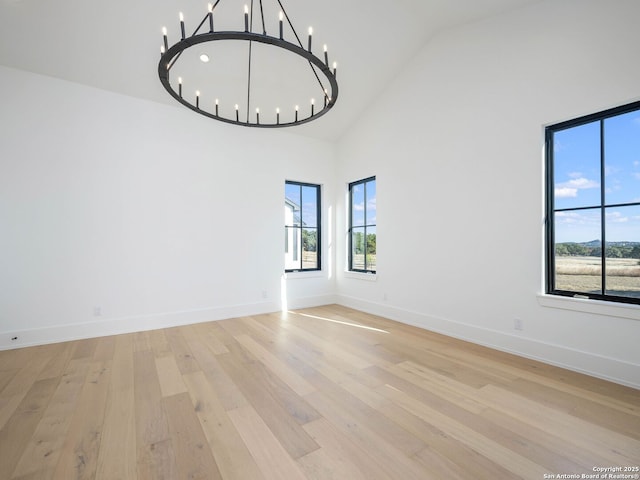 interior space with high vaulted ceiling, a chandelier, and light hardwood / wood-style floors