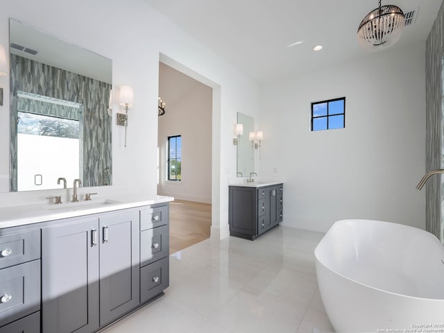 bathroom featuring tile patterned flooring, a bath, and vanity