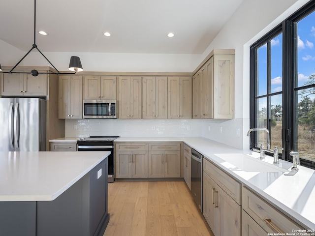 kitchen with decorative light fixtures, decorative backsplash, sink, and appliances with stainless steel finishes