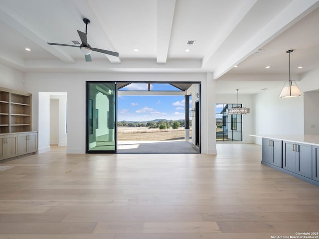 unfurnished living room featuring beamed ceiling, ceiling fan with notable chandelier, light hardwood / wood-style floors, and built in features