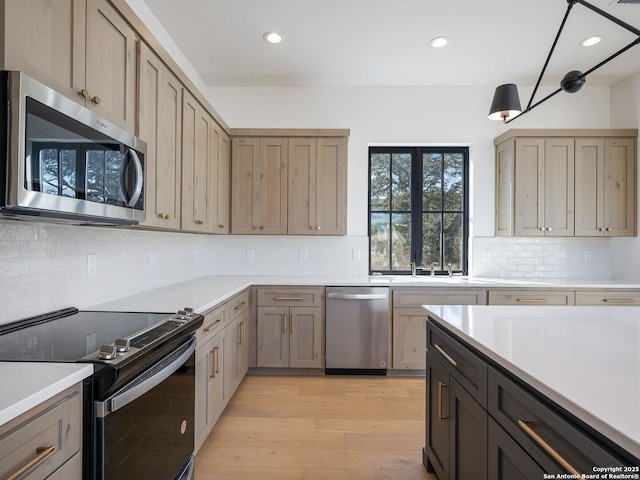 kitchen featuring tasteful backsplash, stainless steel appliances, and light hardwood / wood-style flooring