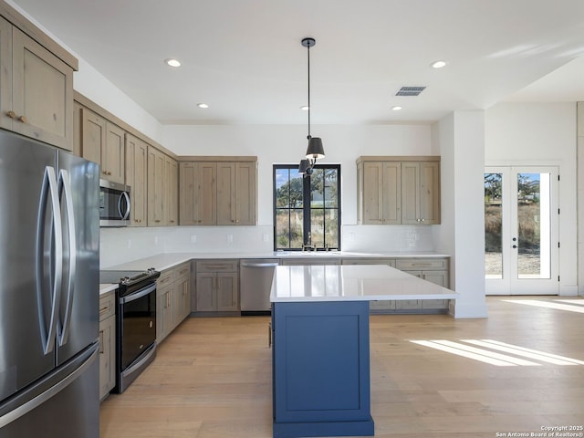 kitchen with french doors, stainless steel appliances, pendant lighting, decorative backsplash, and a kitchen island