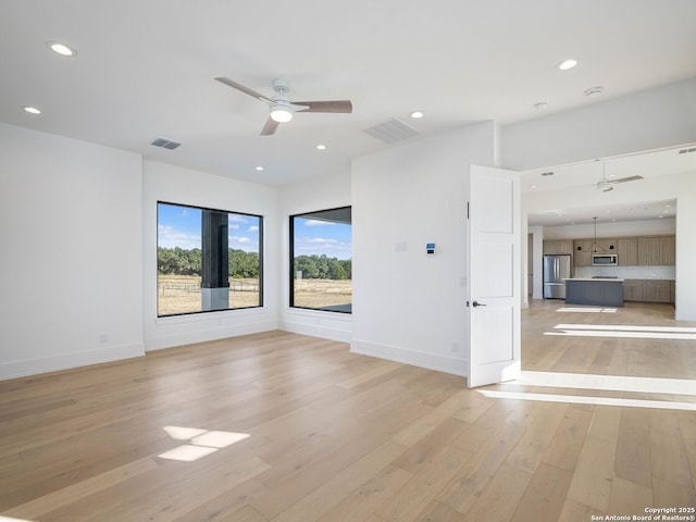 unfurnished room featuring light wood-type flooring and ceiling fan