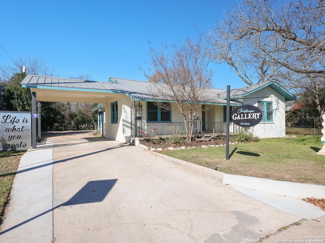 view of front of house with a porch, a front yard, and a carport