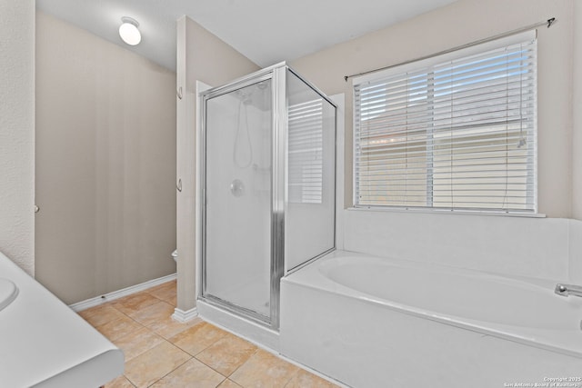 bathroom featuring plus walk in shower, vanity, and tile patterned floors