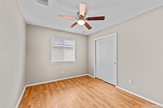 unfurnished bedroom with a closet, light hardwood / wood-style floors, and ceiling fan