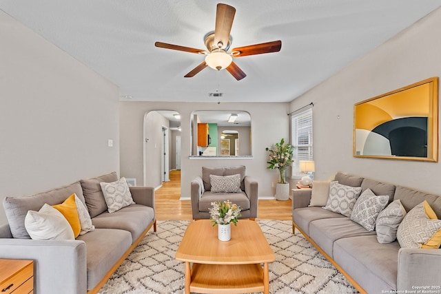 living room with ceiling fan and light hardwood / wood-style flooring