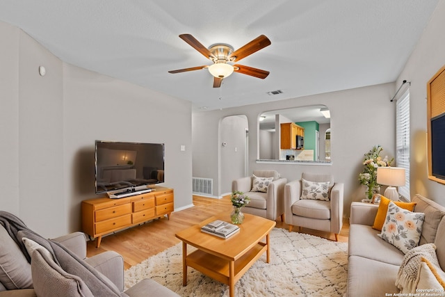 living room with ceiling fan and light hardwood / wood-style flooring