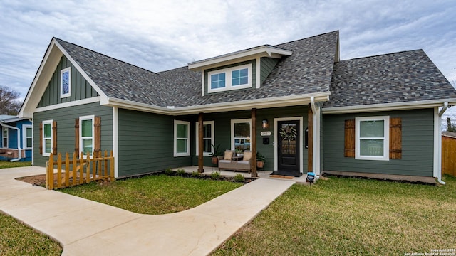 bungalow-style house featuring covered porch and a front yard