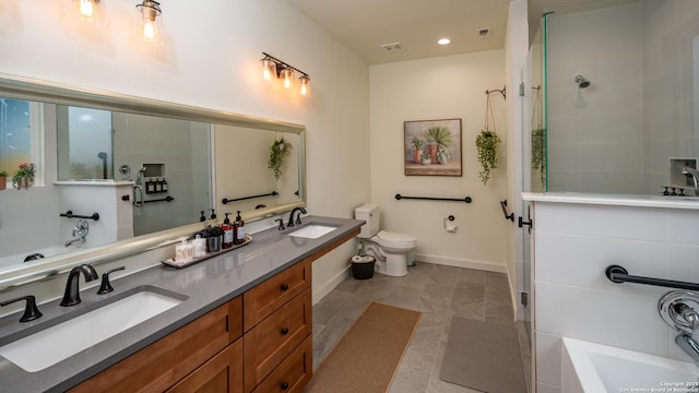 bathroom with a washtub, vanity, and toilet