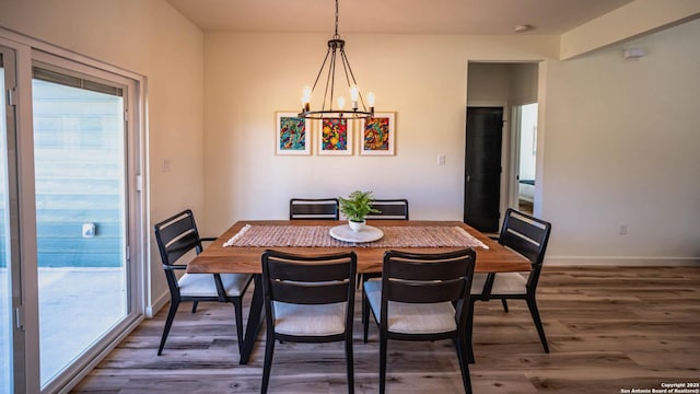 dining space featuring a chandelier, a healthy amount of sunlight, and dark wood-type flooring