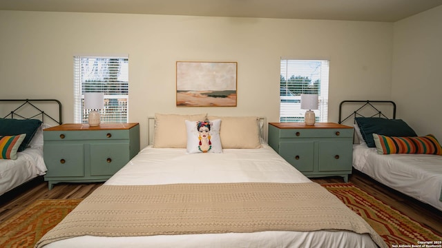 bedroom with dark wood-type flooring and multiple windows