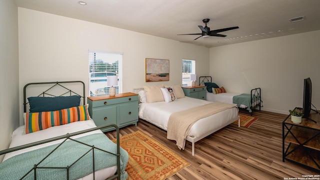 bedroom with multiple windows, hardwood / wood-style flooring, and ceiling fan