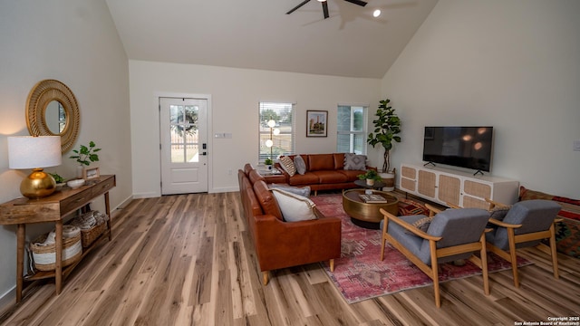 living room featuring hardwood / wood-style flooring, high vaulted ceiling, and ceiling fan