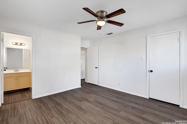 unfurnished bedroom featuring connected bathroom, ceiling fan, sink, and dark hardwood / wood-style floors