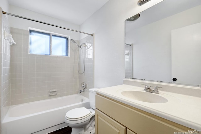 full bathroom with toilet, vanity, and tiled shower / bath