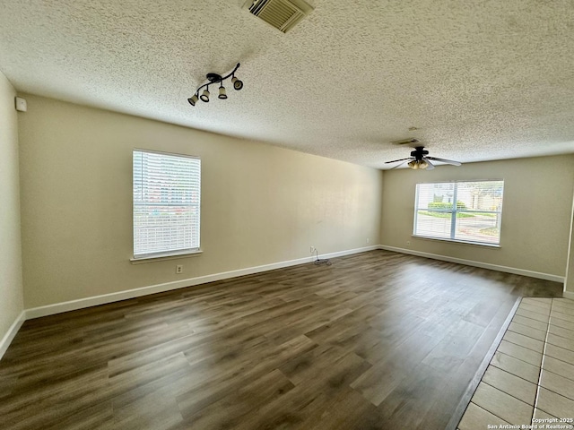 unfurnished room with ceiling fan, dark wood-type flooring, and a textured ceiling