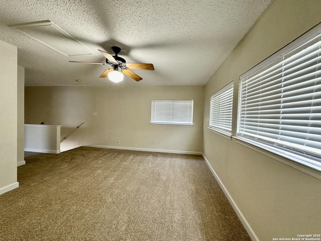 carpeted empty room with ceiling fan and a textured ceiling