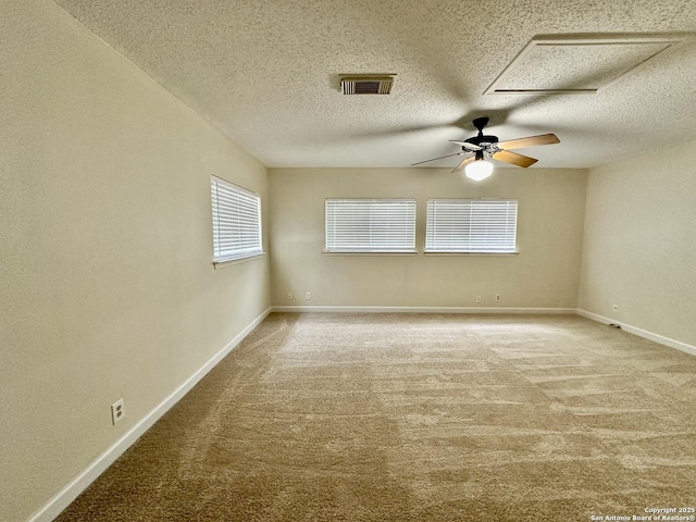 empty room with carpet flooring, ceiling fan, and a textured ceiling