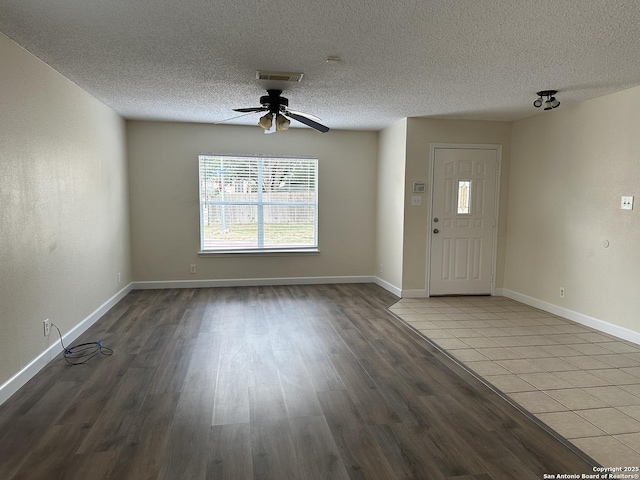 foyer entrance featuring wood-type flooring, a textured ceiling, and ceiling fan