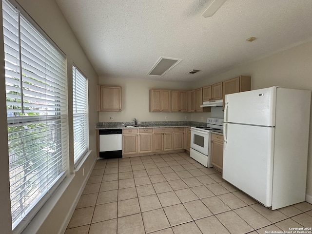 kitchen with light tile patterned flooring, light brown cabinetry, white appliances, and sink