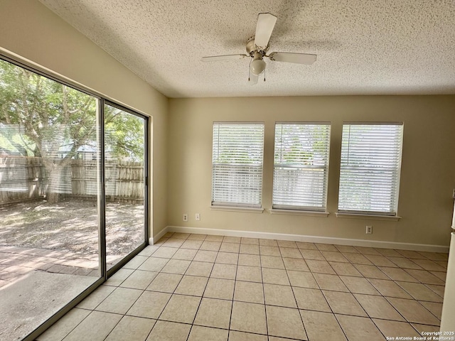 unfurnished sunroom featuring ceiling fan and a healthy amount of sunlight