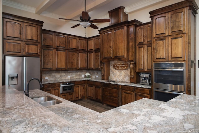 kitchen featuring backsplash, stainless steel appliances, ceiling fan, sink, and beamed ceiling