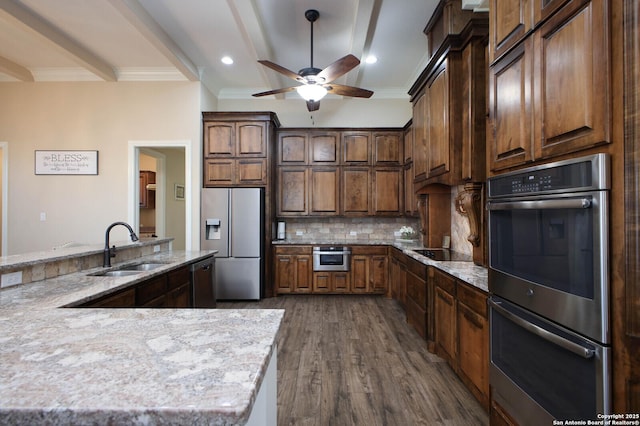 kitchen featuring sink, decorative backsplash, ceiling fan, appliances with stainless steel finishes, and dark hardwood / wood-style flooring