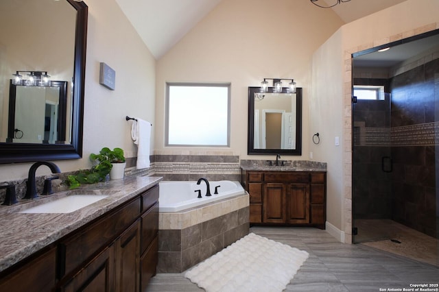 bathroom featuring separate shower and tub, vanity, and lofted ceiling