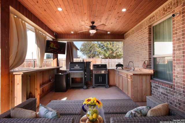 view of patio / terrace with area for grilling, ceiling fan, an outdoor wet bar, and exterior kitchen