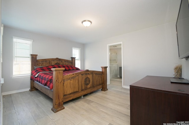 bedroom featuring ensuite bathroom and light hardwood / wood-style flooring