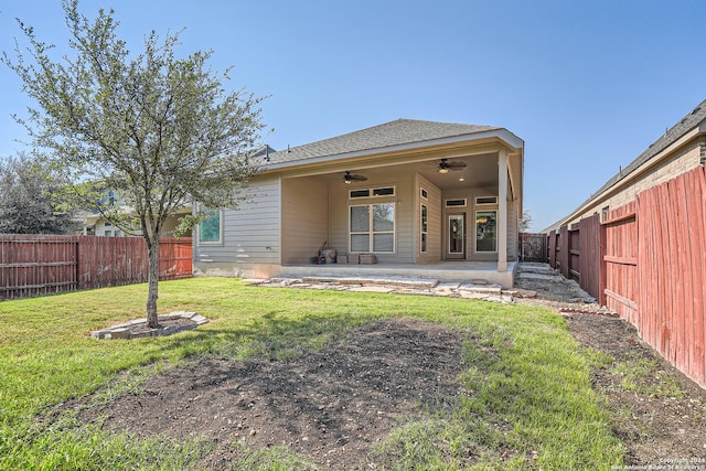 back of property with a lawn, a patio area, and ceiling fan