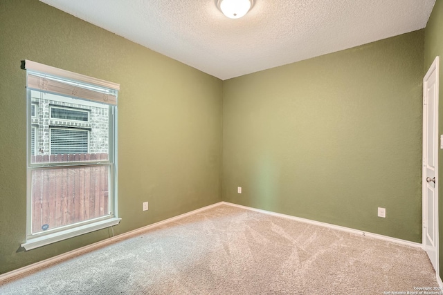 spare room featuring carpet flooring and a textured ceiling