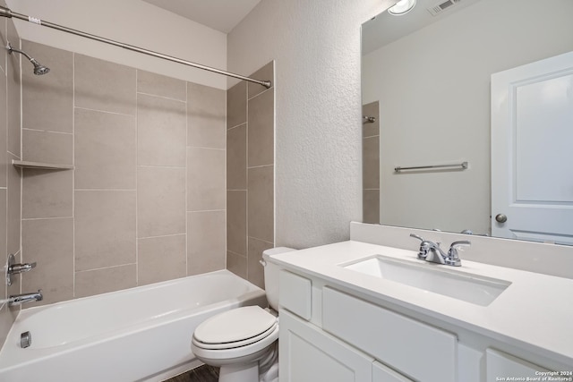 full bathroom featuring vanity, tiled shower / bath combo, and toilet