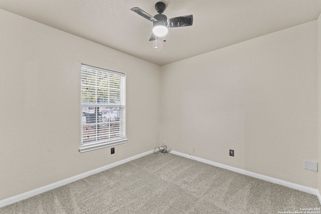 unfurnished room with ceiling fan and carpet