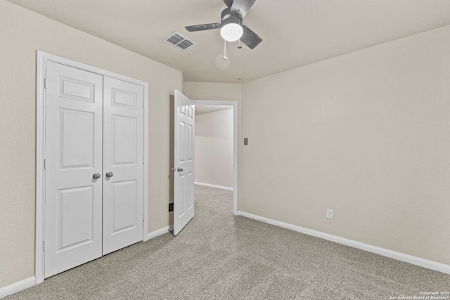 unfurnished bedroom featuring a closet, ceiling fan, and light colored carpet