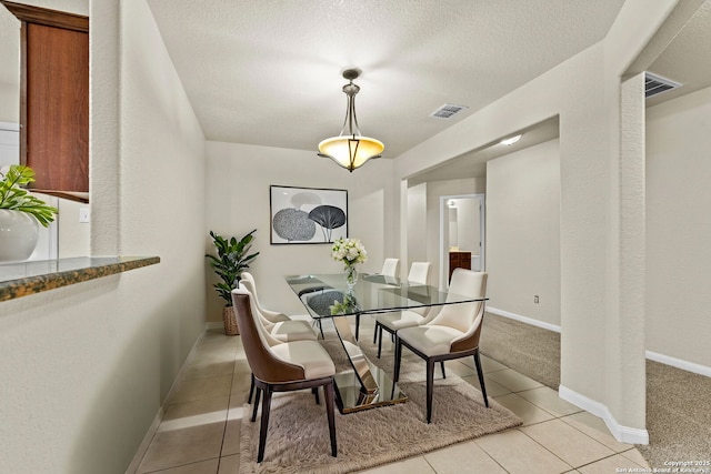 dining area with light tile patterned floors and a textured ceiling