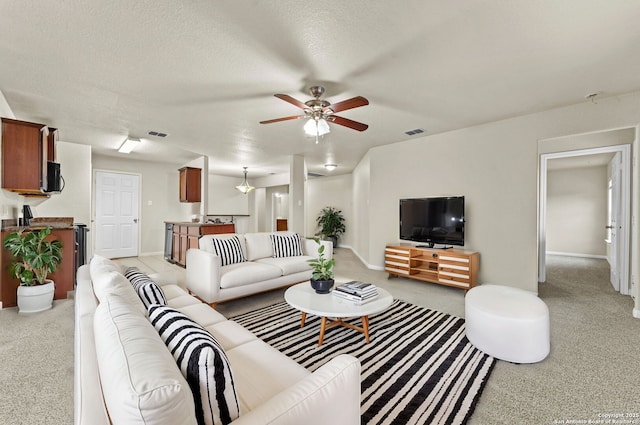 living room with ceiling fan and a textured ceiling