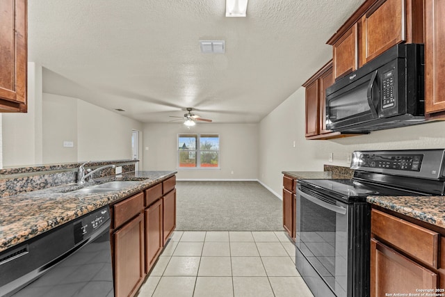 kitchen featuring black appliances, dark stone countertops, light colored carpet, and sink