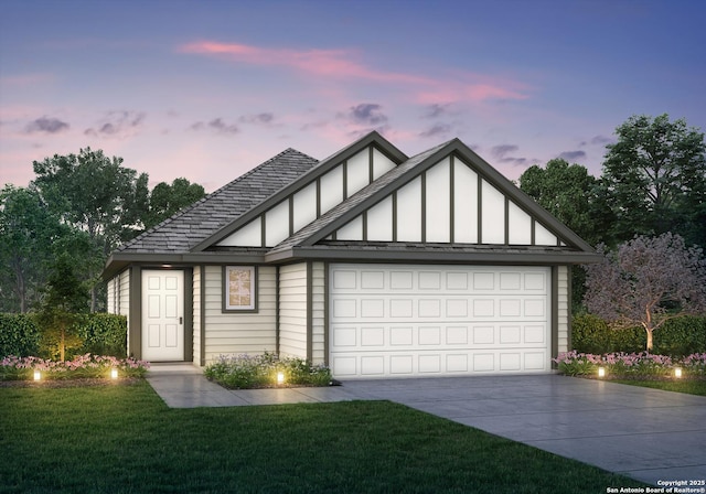 view of front of home with a garage and a lawn