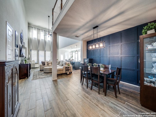 dining space featuring an inviting chandelier and a high ceiling