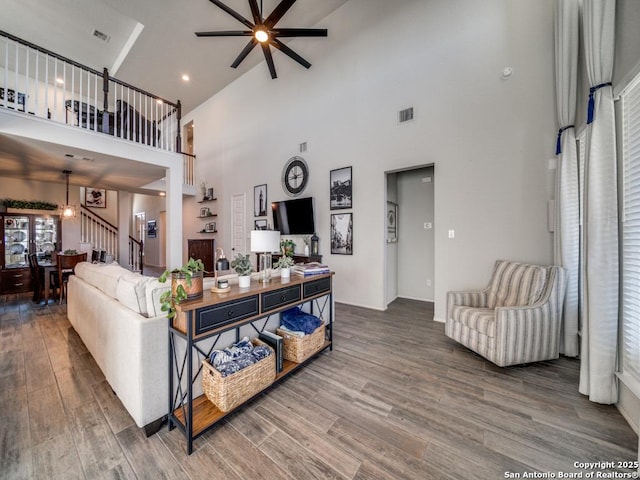 living room with ceiling fan, high vaulted ceiling, and hardwood / wood-style floors