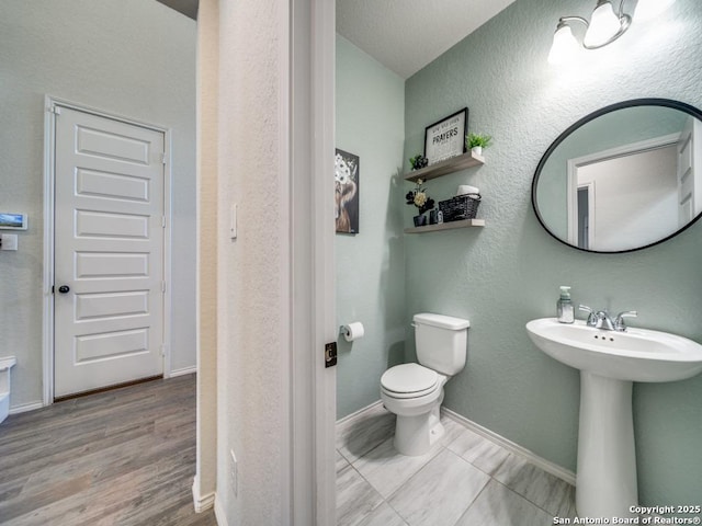 bathroom with sink, toilet, and wood-type flooring