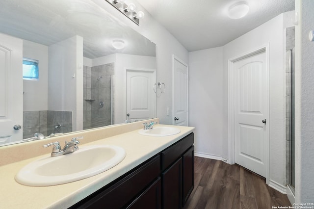 bathroom featuring a textured ceiling, vanity, hardwood / wood-style flooring, and walk in shower